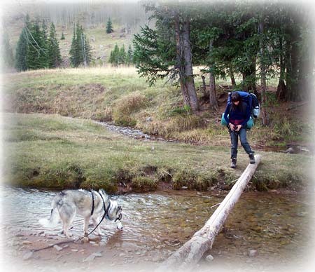 Laila crosses creek to camp site